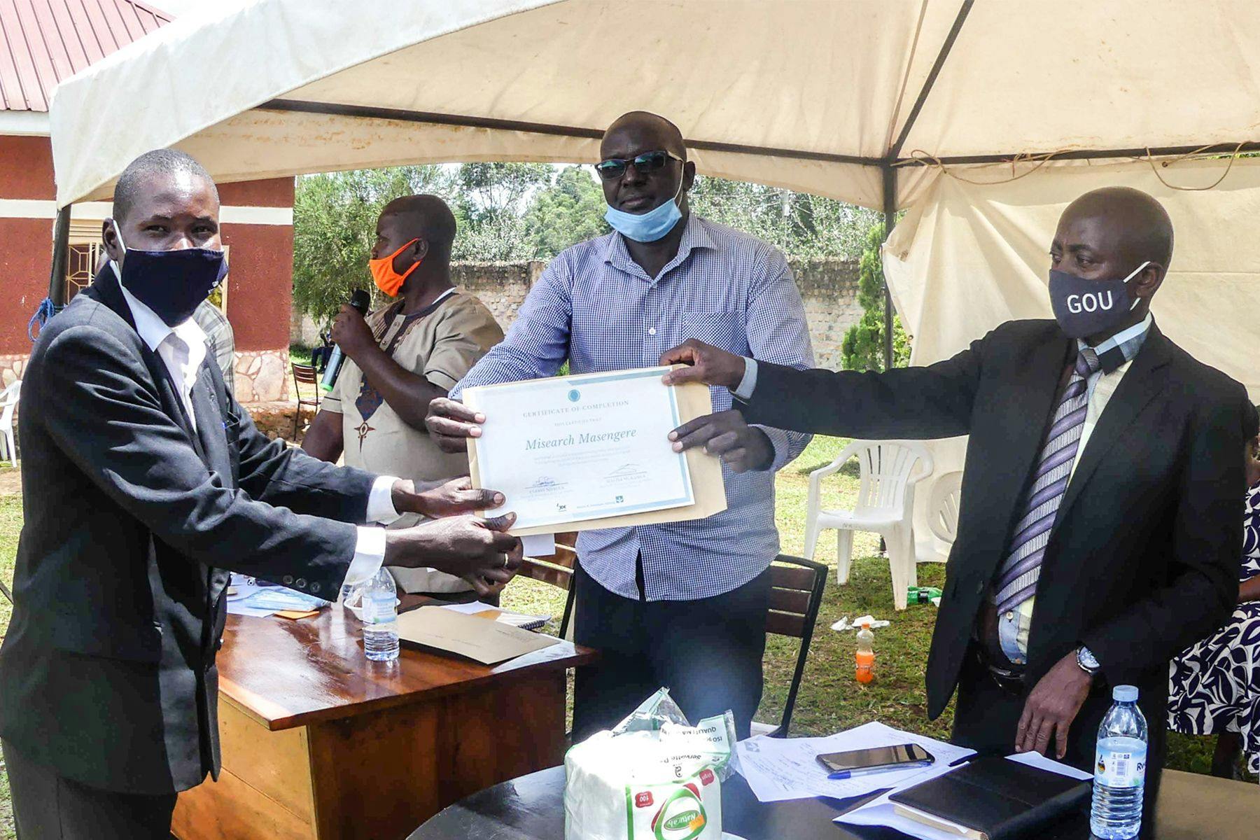 Misearch receiving his certificate at the UCAT Kakumiro close-out ceremony
