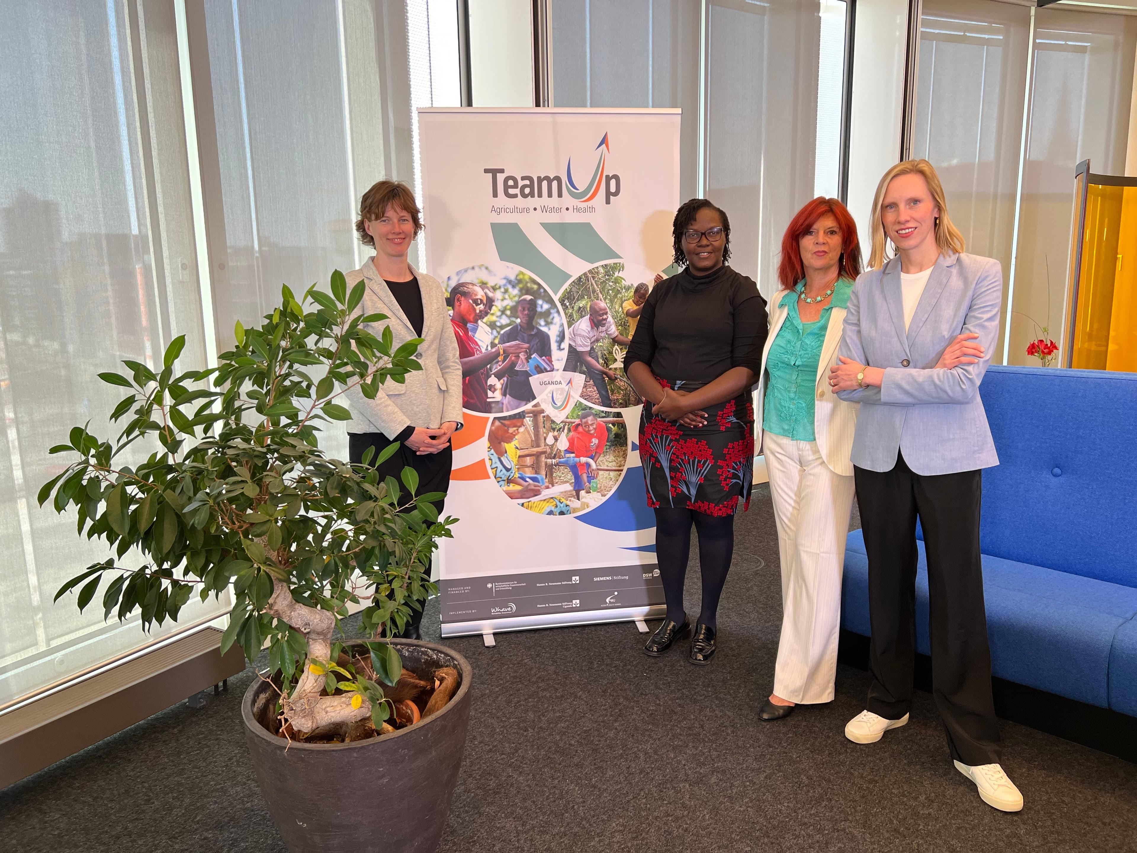 Panelists and moderator in front of banner Panelists and moderator in front of banner